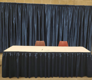 Booth; Deluxe - One 8ft skirted table w/ white table-cloth, back drop & two chairs.
