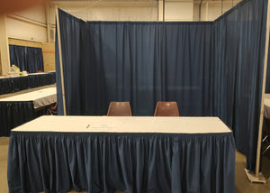 Booth; Deluxe - One 8ft skirted table w/ white table-cloth, back drop & two chairs.